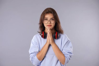 İyi bir sınav için dua eden öğrenci gri arka planda sonuç aldı