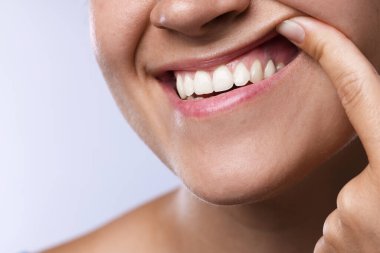 Dişlerini ve diş etlerini arka planda gösteren kadın, yakın plan.