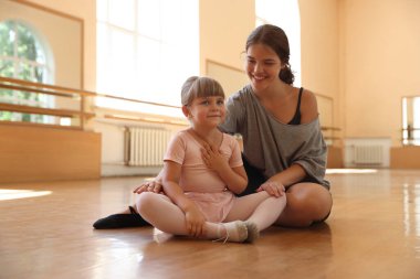 Dans sınıfında küçük bir kızla çalışırken mutlu bir bale öğretmeni.