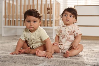 Evde yerde tatlı küçük ikiz bebekler