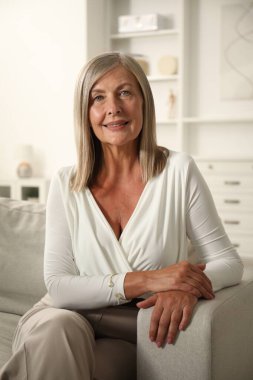 Evdeki kanepede son sınıf öğrencisi zarif bir kadın.