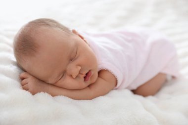 Yeni doğmuş şirin bebek evde yatakta uyuyor.