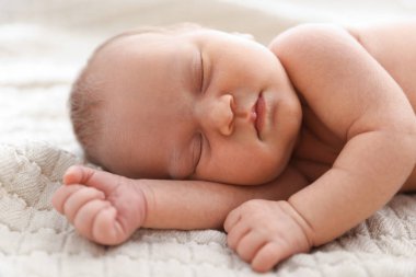 Yeni doğmuş şirin bebek evde yatakta uyuyor.
