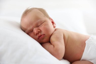 Yeni doğmuş şirin bebek yastıkta uyuyor.