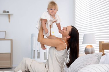 Annesi ve tatlı bebeği yataktaki odada.