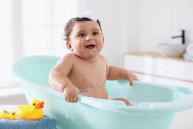 Evde küvette banyo yapan şirin bir bebek.