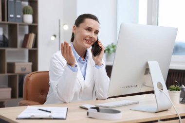 Akıllı telefonlu doktor klinikte online danışmanlık yapıyor.