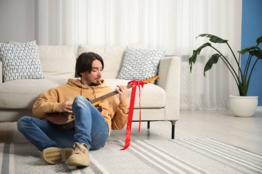 Hayaller gerçek olur. Evde gitarı olan mutlu bir adam, mesaj için yer var.