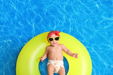 Yüzme havuzunda şişirilebilir yüzüklü şirin bir bebek.
