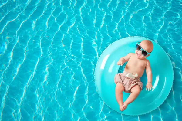 Yüzme havuzunda şişirilebilir yüzüklü şirin bir bebek.
