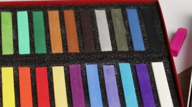 Masada renkli tebeşirli pastel boya seti, yakın plan. Kamera sağa hareket ediyor