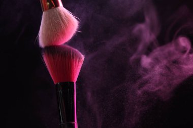 Siyah arka planda pembe göz farlı makyaj fırçaları, yakın plan. Metin için boşluk