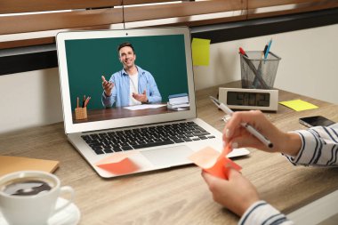 E-öğrenme konsepti. Öğrenci, bilgisayar aracılığıyla öğretmeniyle görüntülü konuşma yapıyor.