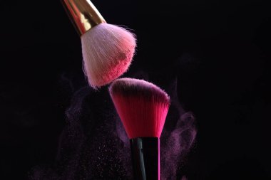 Siyah arka planda pembe göz farlı makyaj fırçaları, yakın plan