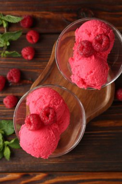 Tatlı kaselerinde nefis ahududu şerbeti, ahşap masada nane ve taze böğürtlen, düz uzanmış