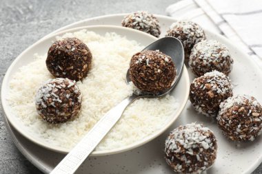 Gri masada hindistan cevizi gevreğiyle lezzetli çikolatalar yapmak, yakın plan.