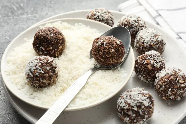 Gri masada hindistan cevizi gevreğiyle lezzetli çikolatalar yapmak, yakın plan.