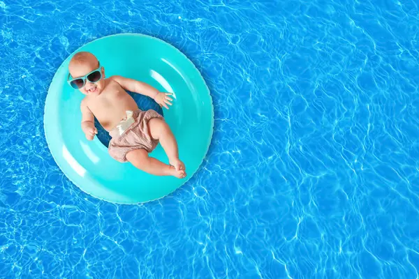 Yüzme havuzunda şişirilebilir yüzüklü şirin bir bebek. Metin için boşluk