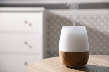 Ahşap masa üzerinde şık bir aroma lambası, yakın plan. Metin için boşluk