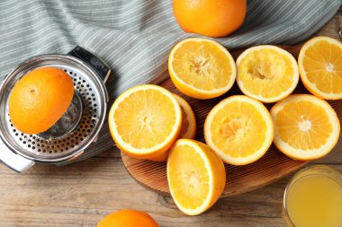 Taze sıkılmış portakal suyu, meyve suyu ve meyve sıkacağı ahşap masada, düz yerde.