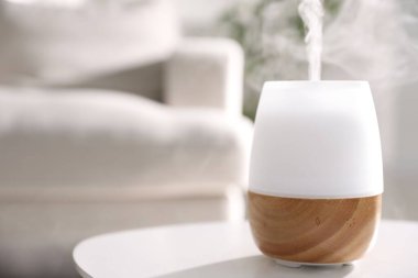 Beyaz masa üzerinde şık bir aroma lambası, yakın plan. Metin için boşluk