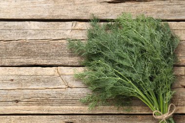 Ahşap masanın üstünde taze dereotları var. Metin için boşluk