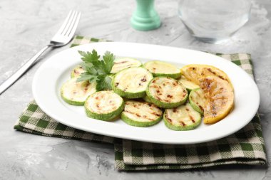 Gri masada servis edilen limonlu ve maydanozlu lezzetli kabak dilimleri.