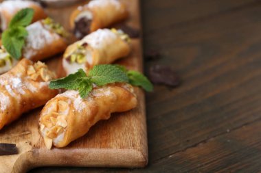 Peynirli, fındıklı, çikolatalı, naneli ve pudra şekerli nefis canoli, yakın plan. Metin için boşluk