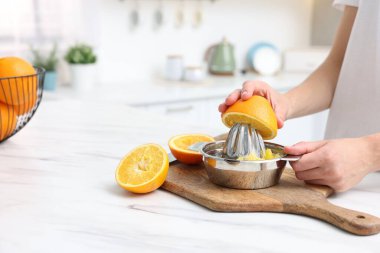 Meyve suyu. İçerideki masada portakal suyu kullanan kadın, yakın plan. Metin için boşluk