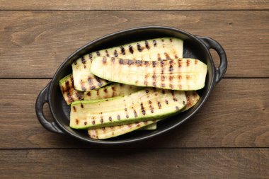 Ahşap masadaki fırın tabağında nefis ızgara kabak dilimleri.