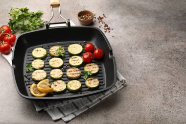 Gri desenli masada domatesli, limonlu ve maydanozlu leziz ızgara kabak dilimleri, yakın plan. Metin için boşluk