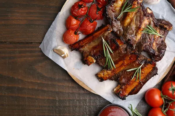 Ahşap masada baharatlı ve domatesli ızgara sığır kaburgası. Metin için boşluk