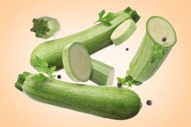 Taze kabaklar, maydanoz ve bej renkli arkaplana düşen biberler.