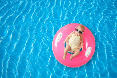 Yüzme havuzunda şişirilebilir yüzüklü şirin bir bebek. Metin için boşluk