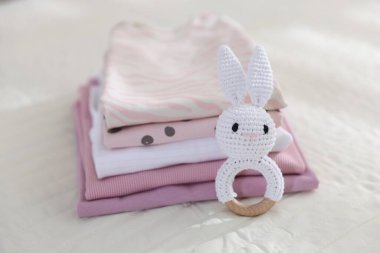 Temiz bebek kıyafetleri ve çarşaflara aksesuar yığını.