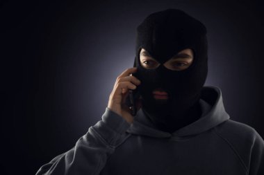 Maskeli bir suçlu karanlık geçmişiyle telefonda konuşuyor. Metin için boşluk