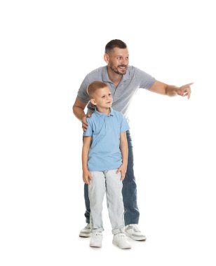 Babası beyaz arka planda oğluna bir şey gösteriyor.