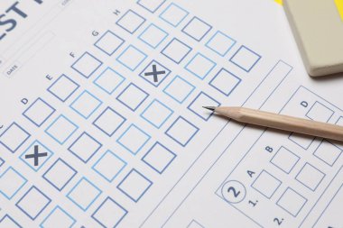 Cevap kağıdı, kalem ve silgi, yakın plan. Öğrenci sınavını geçti