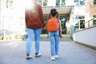 Anne kızını açık hava okuluna götürüyor.