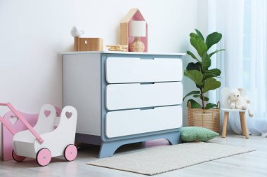 Mobilyaları, oyuncakları ve çiçekleri olan şık bir oyun odası. İç tasarım