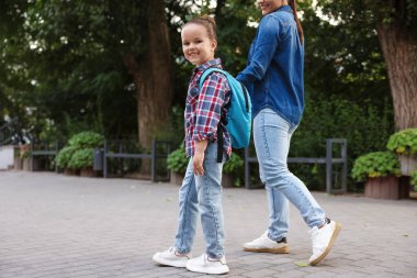 Anne kızını açık hava okuluna götürüyor, yakın çekim.