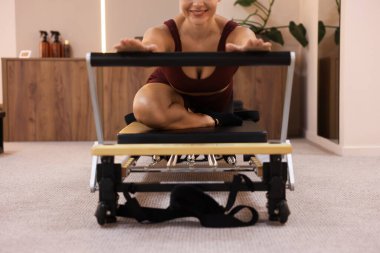 Pilates stüdyosunda yenilikçi kadın egzersizi, yakın çekim.