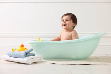 Evde küvette banyo yapan şirin bir bebek.