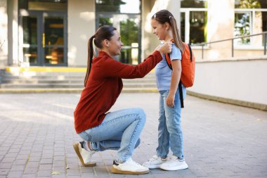 Anne kızını açık hava okuluna götürüyor.