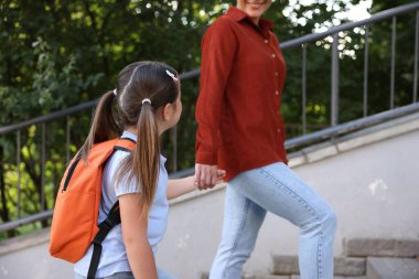 Anne kızını açık hava okuluna götürüyor, yakın çekim.