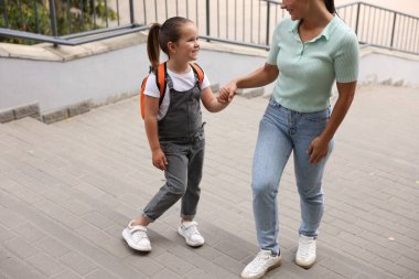 Anne kızını açık hava okuluna götürüyor, yakın çekim.