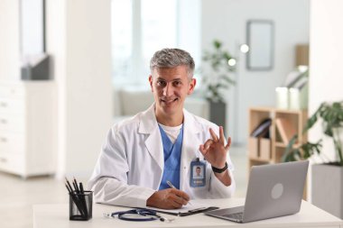 Teletıp. Doktor içeride bilgisayarla hastayla görüntülü konuşma yaparken not alıyor.