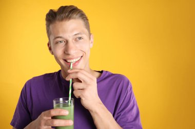 Turuncu arka planda samandan meyve suyu içen adam, metin için boşluk