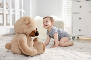 Odasında oyuncak ayı olan şirin bir bebek.