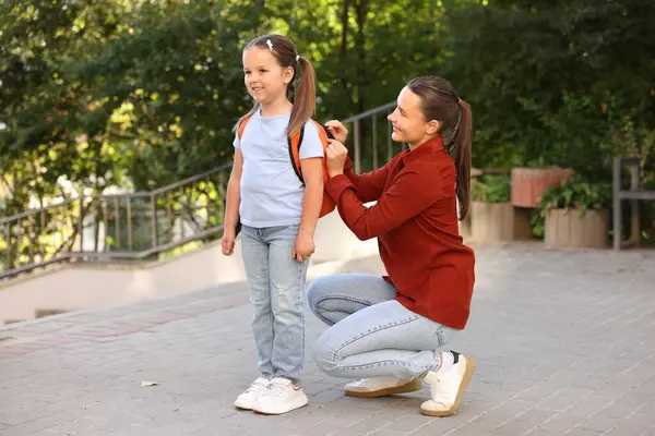 Anne kızını açık hava okuluna götürüyor.